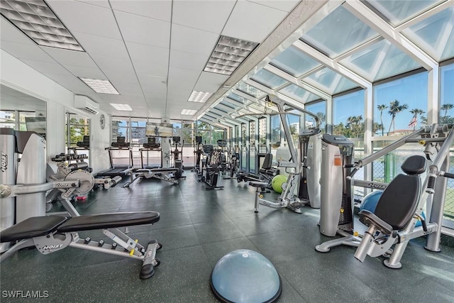 workout area featuring a wall mounted AC and a drop ceiling