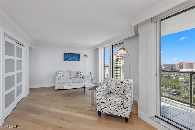 sitting room with a healthy amount of sunlight, ornamental molding, and light hardwood / wood-style flooring