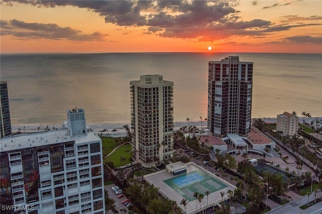 aerial view at dusk featuring a water view