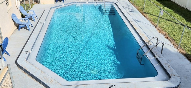 view of pool featuring a lawn