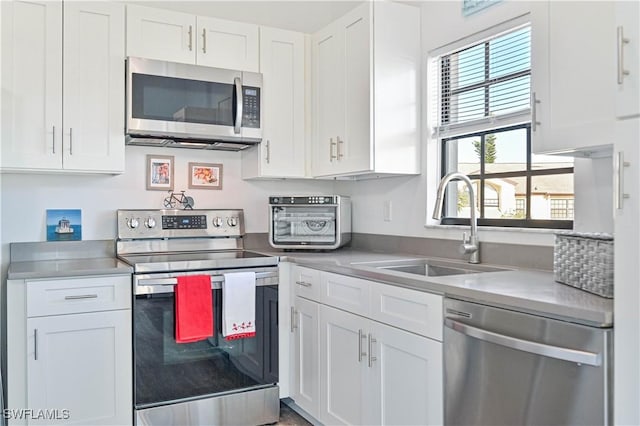 kitchen with sink, white cabinets, and stainless steel appliances