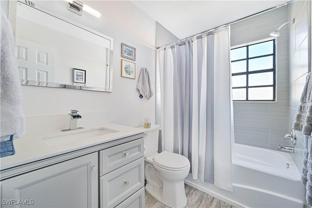 full bathroom featuring shower / bath combo with shower curtain, vanity, wood-type flooring, and toilet