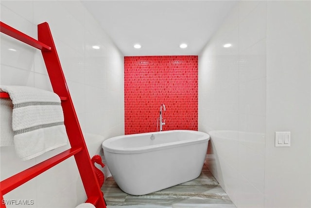 bathroom with tile walls and a bathing tub