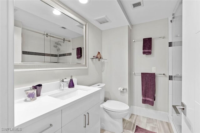 bathroom with vanity, toilet, and a shower with shower door