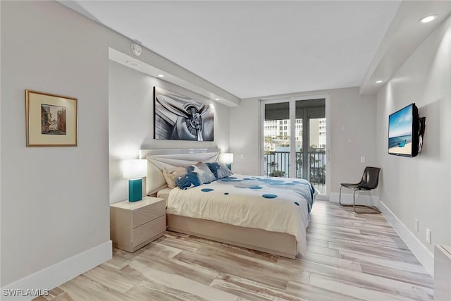 bedroom with light hardwood / wood-style floors and access to exterior