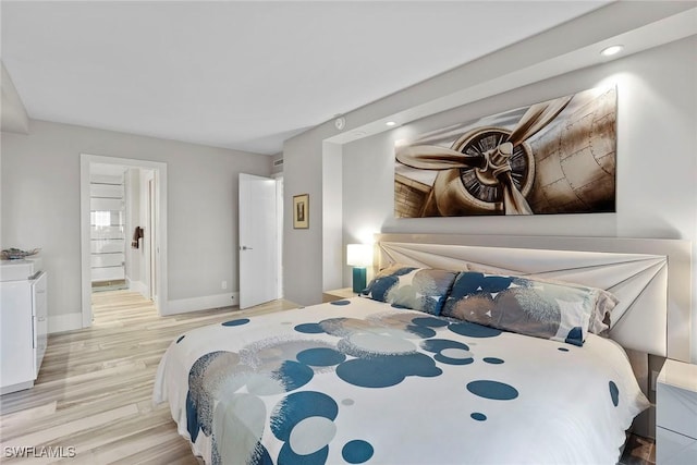 bedroom featuring light wood-type flooring and ensuite bathroom