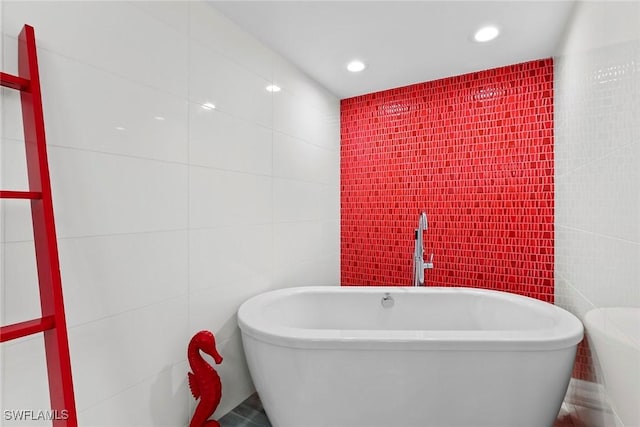 bathroom with a bathtub and tile walls