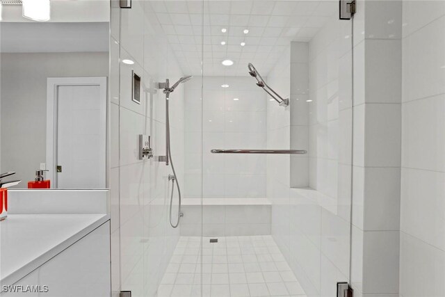 bathroom with vanity and a shower with door