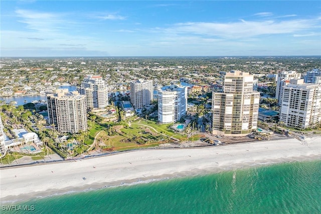 birds eye view of property with a water view and a beach view