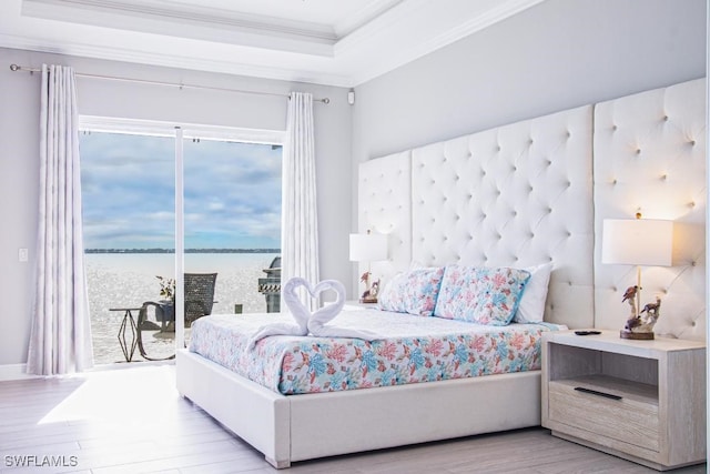 bedroom featuring multiple windows, crown molding, access to outside, and a water view