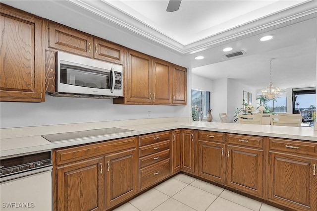 kitchen featuring kitchen peninsula, ceiling fan with notable chandelier, stovetop, hanging light fixtures, and light tile patterned flooring