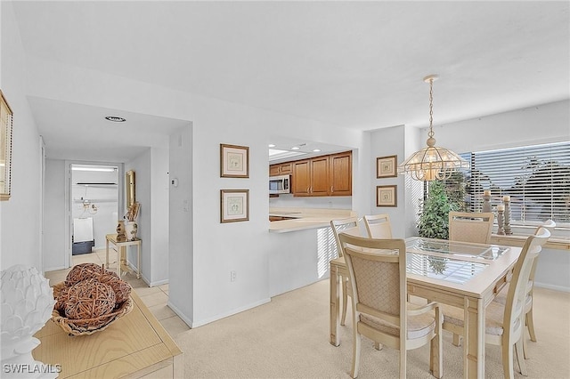 carpeted dining area with a notable chandelier