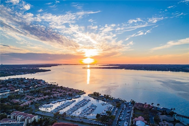 aerial view at dusk featuring a water view