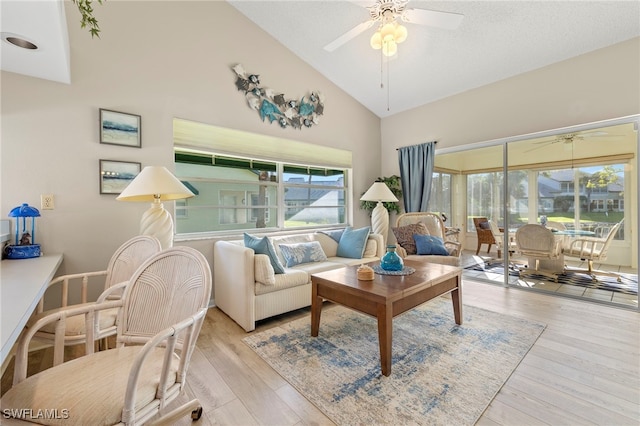 living room with high vaulted ceiling, light hardwood / wood-style flooring, a wealth of natural light, and ceiling fan