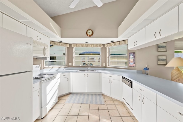 kitchen featuring white cabinetry, light tile patterned flooring, and white appliances