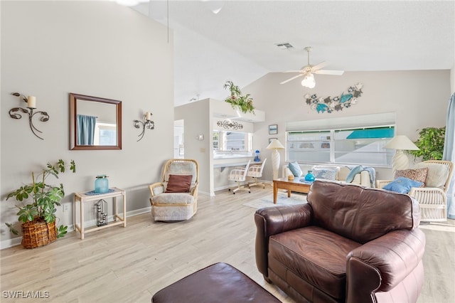 living room with ceiling fan, light hardwood / wood-style flooring, and high vaulted ceiling