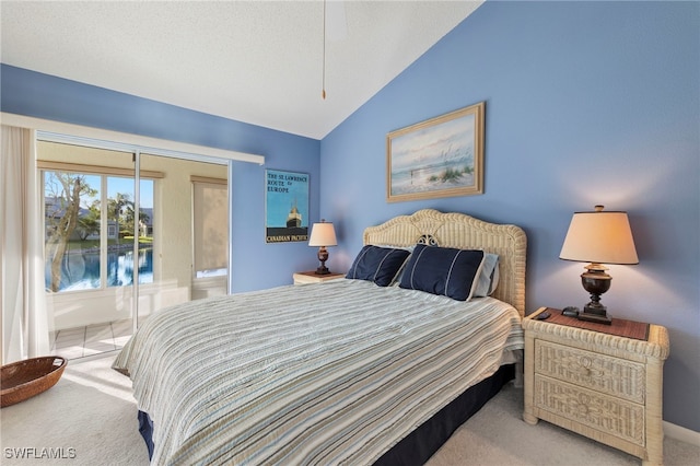 carpeted bedroom featuring a textured ceiling, access to exterior, and lofted ceiling