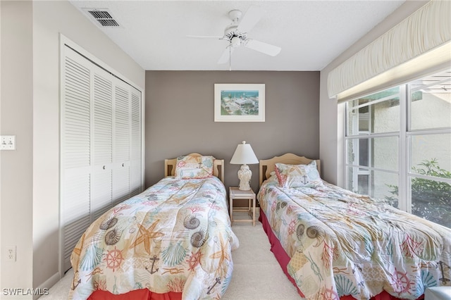 carpeted bedroom with ceiling fan and a closet