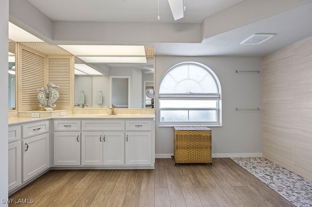 bathroom with wood-type flooring, vanity, and ceiling fan