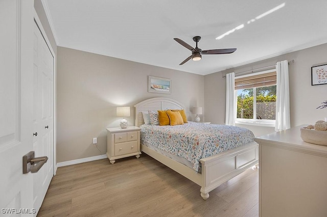 bedroom with ceiling fan, light hardwood / wood-style flooring, and a closet