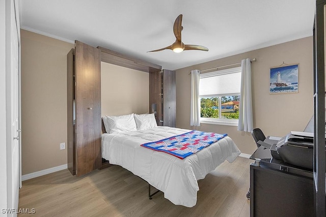 bedroom featuring ceiling fan, light hardwood / wood-style floors, and ornamental molding