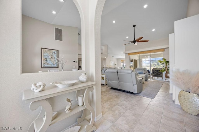 living room with ceiling fan, light tile patterned floors, and lofted ceiling