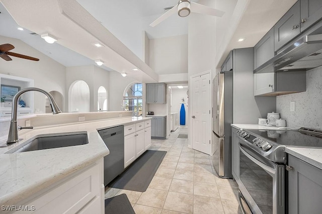 kitchen with gray cabinetry, sink, appliances with stainless steel finishes, and vaulted ceiling