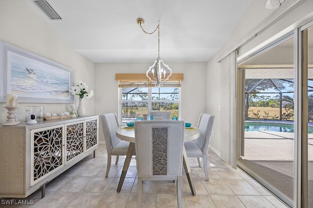 tiled dining space with plenty of natural light and a notable chandelier