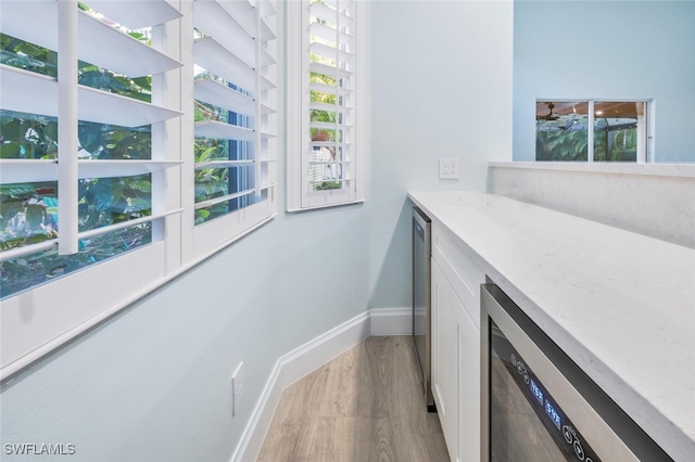 laundry room featuring light wood-type flooring and beverage cooler