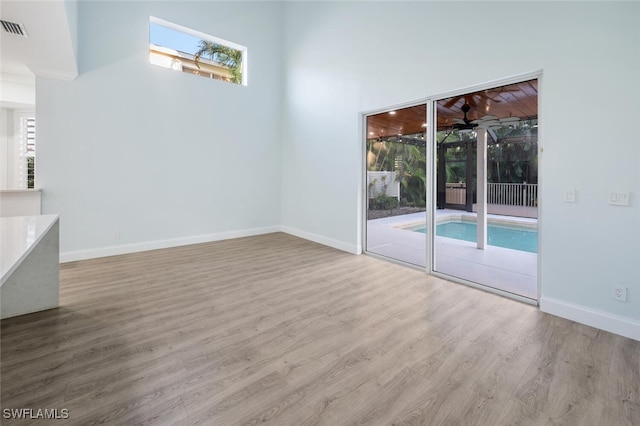 interior space featuring a high ceiling and light wood-type flooring