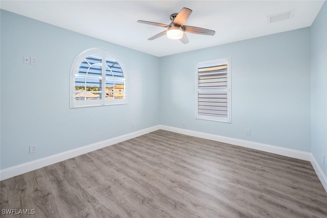 empty room with hardwood / wood-style flooring and ceiling fan