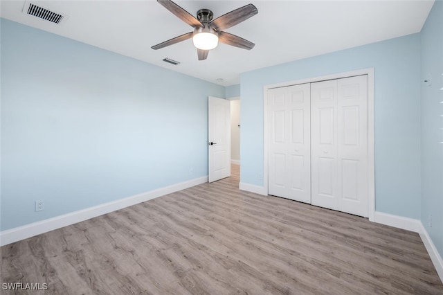 unfurnished bedroom featuring ceiling fan, light hardwood / wood-style floors, and a closet