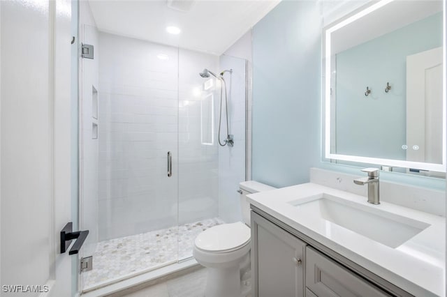 bathroom featuring vanity, toilet, and an enclosed shower