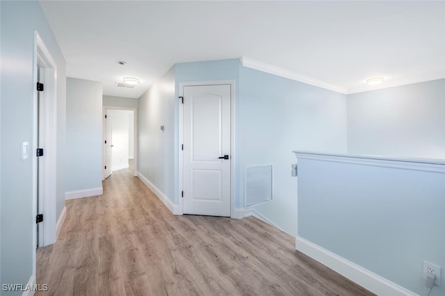 corridor featuring crown molding and light hardwood / wood-style flooring