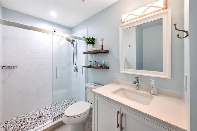 bathroom with vanity, toilet, and a shower with shower door