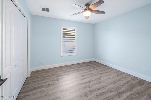 unfurnished bedroom featuring ceiling fan, a closet, and light wood-type flooring