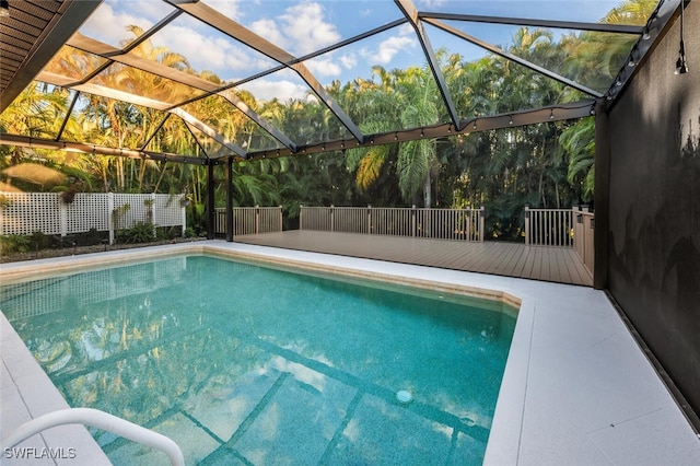 view of pool featuring glass enclosure and a wooden deck