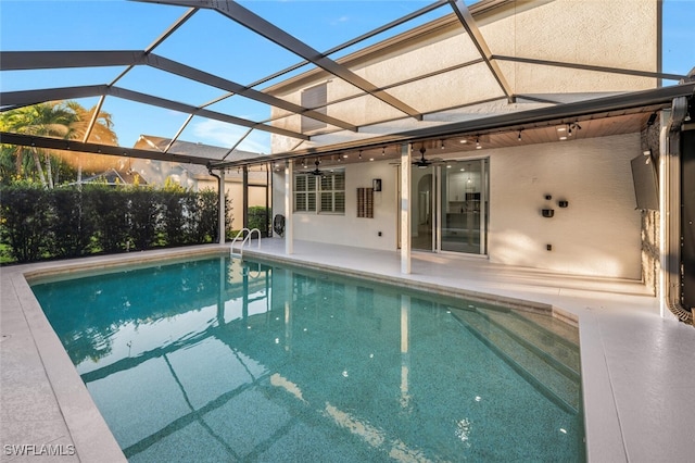 view of swimming pool featuring a patio, ceiling fan, and a lanai