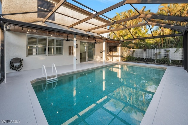 view of pool with glass enclosure, ceiling fan, and a patio area