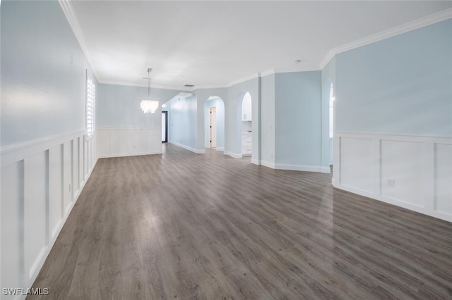 unfurnished living room with a notable chandelier, dark hardwood / wood-style flooring, and ornamental molding