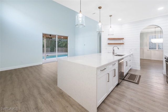 kitchen featuring white cabinets, light hardwood / wood-style flooring, stainless steel dishwasher, and sink