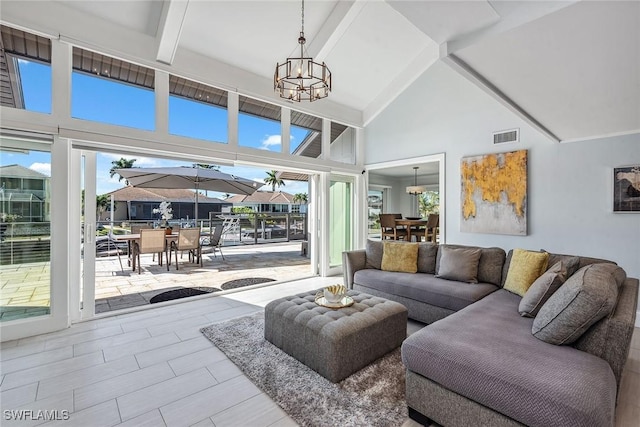 living room featuring beam ceiling, high vaulted ceiling, and an inviting chandelier