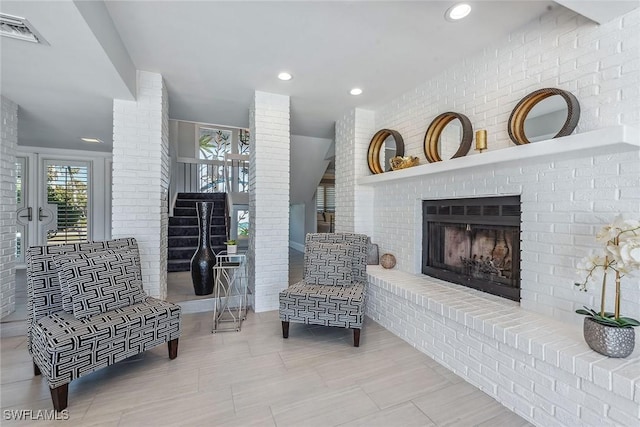 sitting room featuring a brick fireplace and brick wall