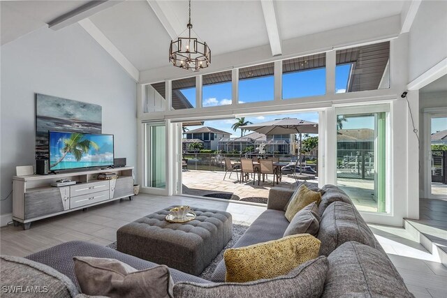 living room with beamed ceiling, high vaulted ceiling, and a notable chandelier