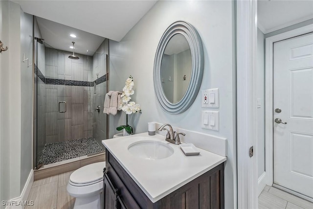 bathroom with hardwood / wood-style floors, vanity, an enclosed shower, and toilet