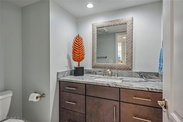 bathroom featuring vanity and toilet