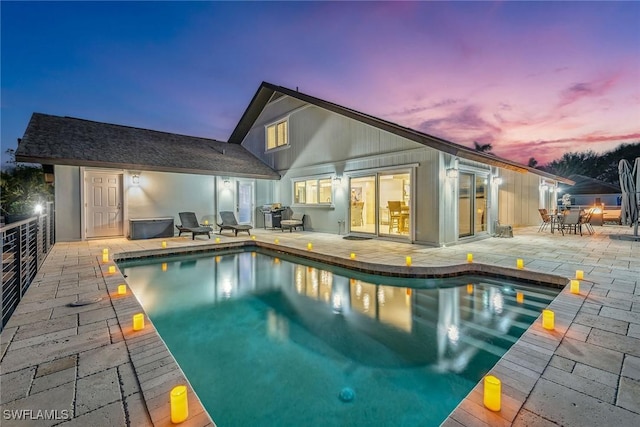 back house at dusk with a patio