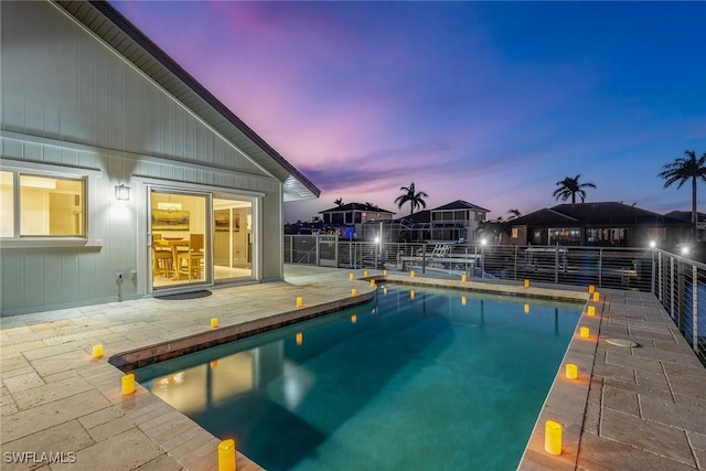 pool at dusk with a patio