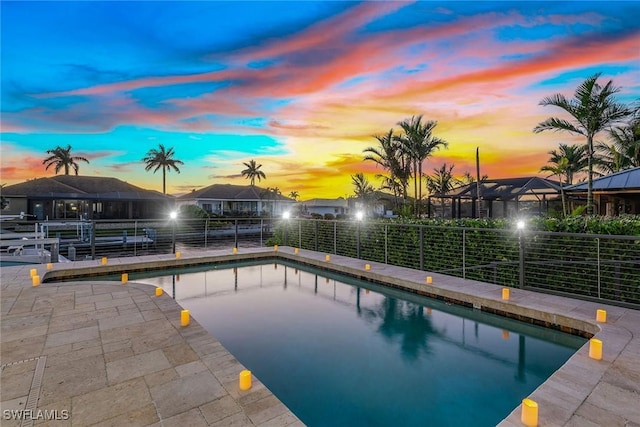 pool at dusk featuring a patio area