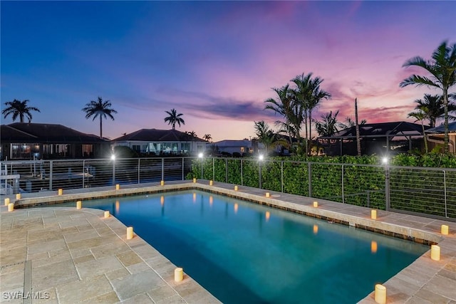 pool at dusk featuring a patio area